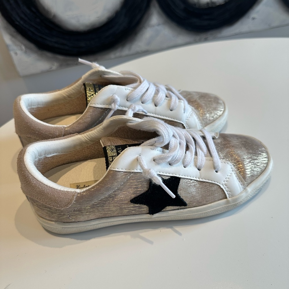 Gold shimmer tennis shoes with black star